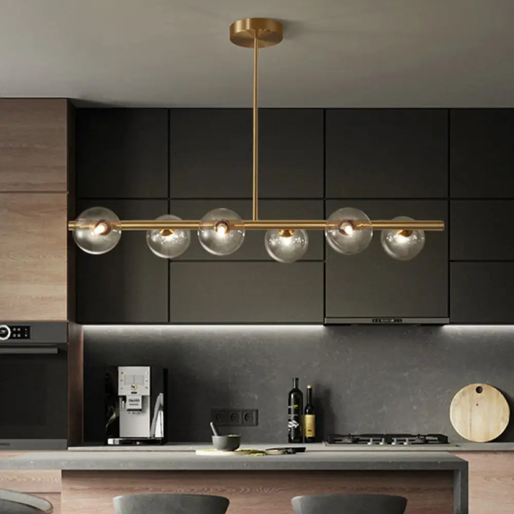 Sleek And Elegant Linear Gold Island Pendant Lighting With Spherical Glass Shades For Dining Table