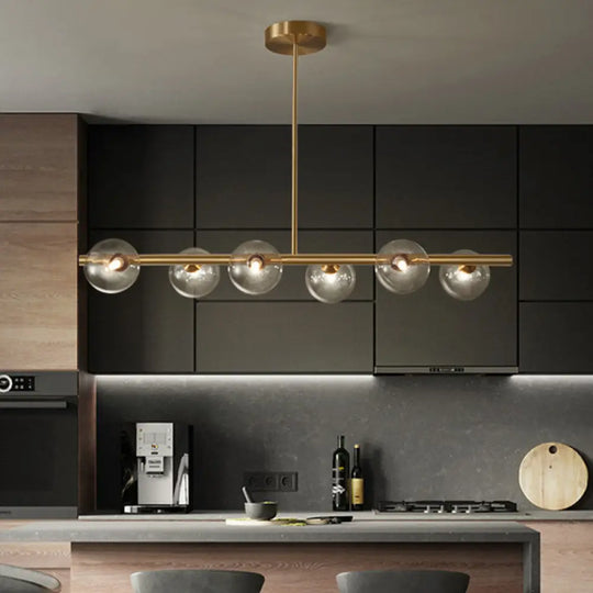 Sleek And Elegant Linear Gold Island Pendant Lighting With Spherical Glass Shades For Dining Table