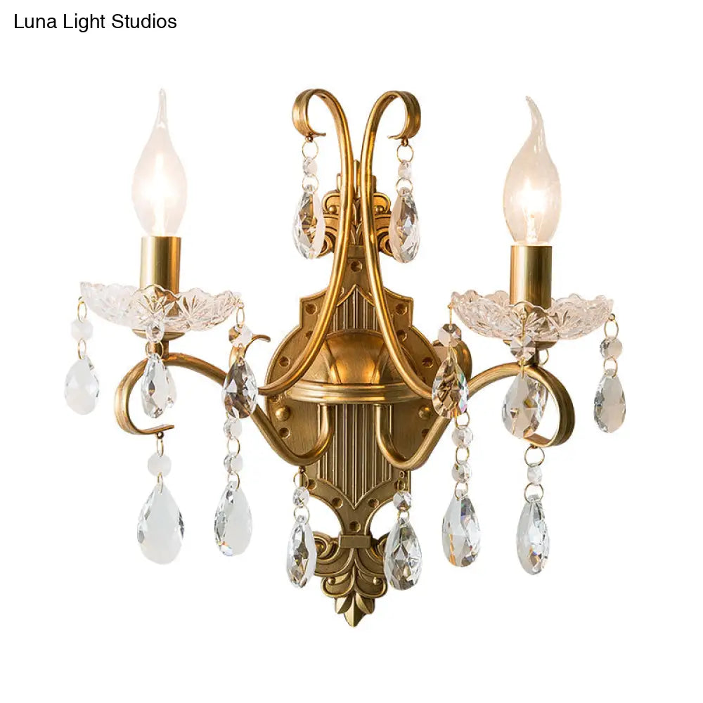 Traditional Crystal Candle Wall Sconce With Antiqued Brass Finish And Scroll Arm